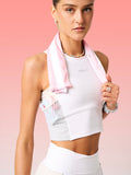 Woman holding a pink towel with a visible brand logo against a pink background